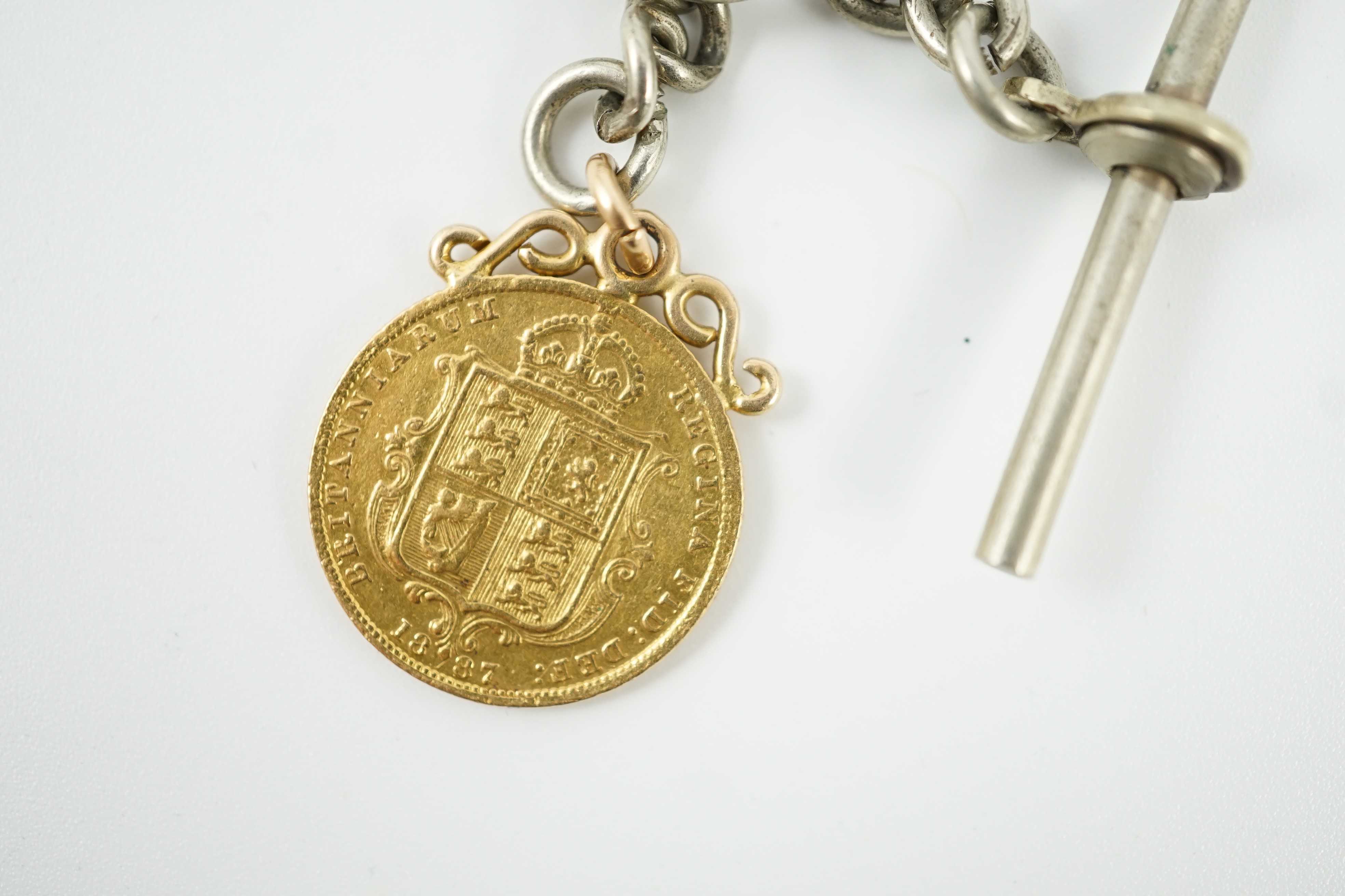 A Victorian 1887 gold half sovereign, on pendant mount and hung from a white metal albert.